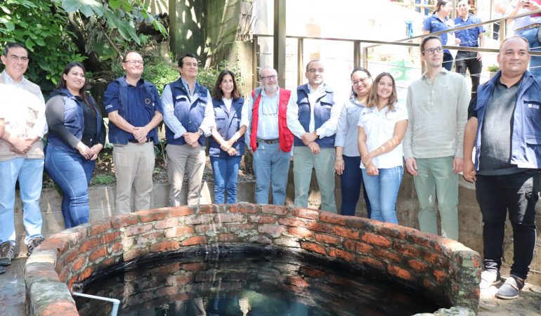 Grupo de personas posando junto a pozo de agua
