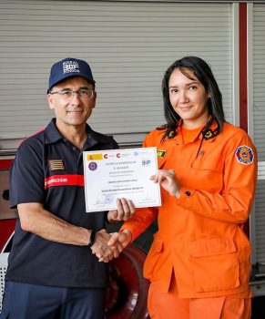 Bombero y bombera sujetando diploma