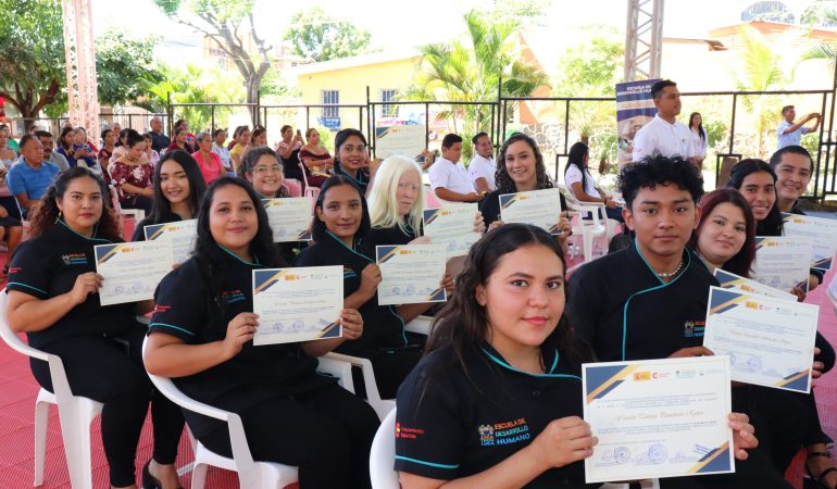 Estudiantes con diplomas en la mano durante la graduación 