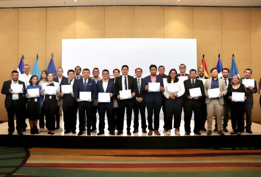 Grupo de personas en el escenario mostrando sus diplomas
