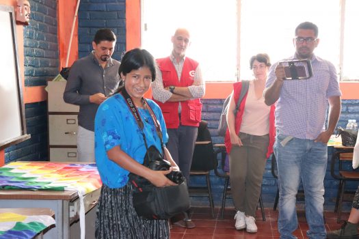 Mujer mostrando su trabajo en el pueblo